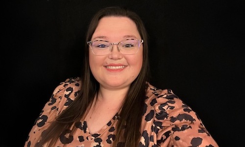 a woman smiling against a black backdrop