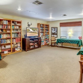 Settle into comfort at Laurel Glen at Stephenville Assisted Living & Memory Care a large room with a bed and bookshelves